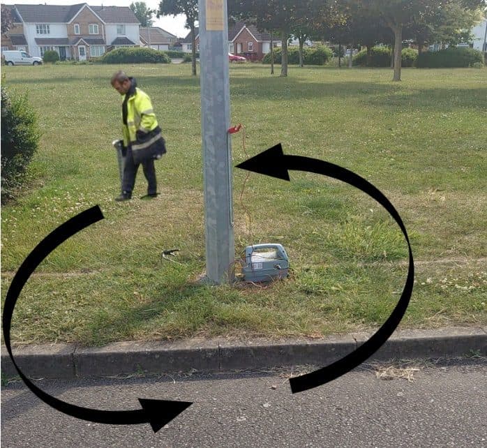 Operative circling a lighting column with the CAT while the Genny sits at its base: the search worked around the column, arrow overlay showing the path.