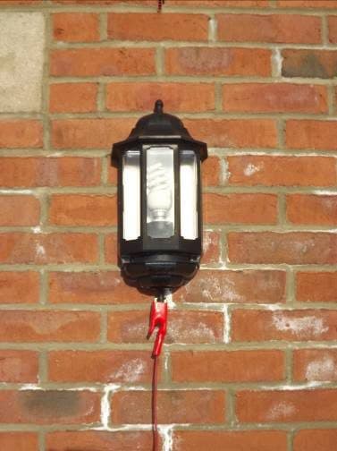 External wall lantern with a red crocodile clip on its supply: using the lighting circuit at a property.