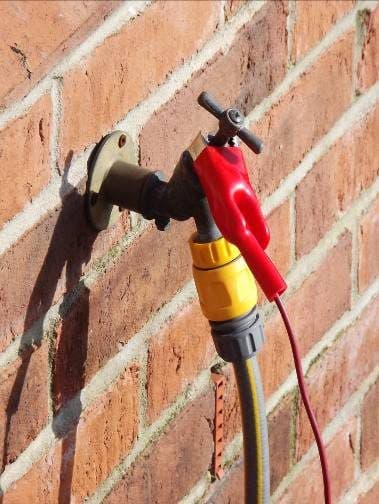 Red clip on an outside tap: using bonded metalwork as the connection point.