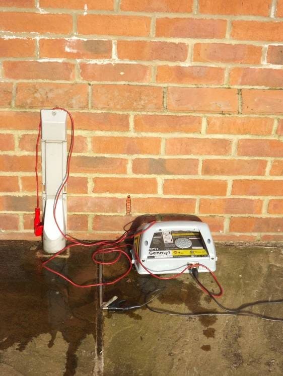 Genny4 connected beneath a white external unit on a brick wall.