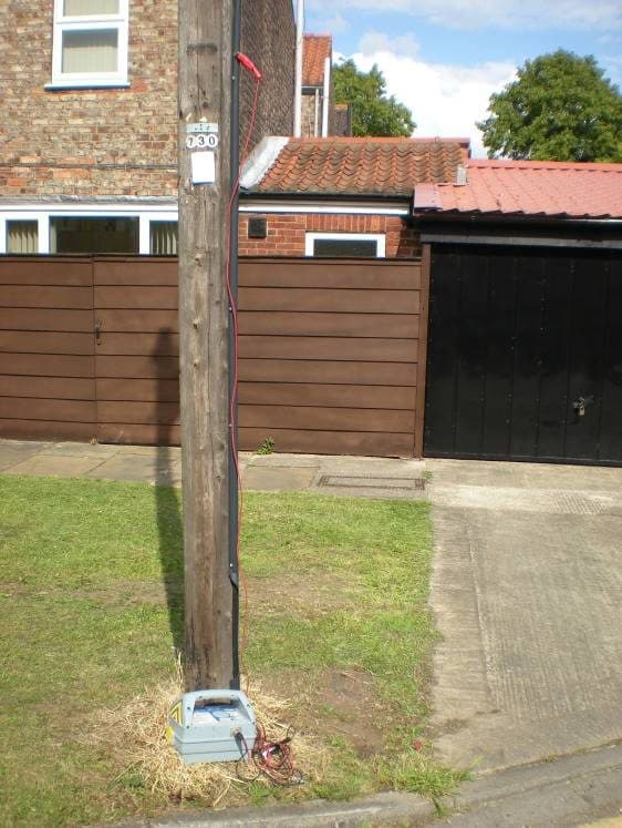 Wooden pole with the supply dropping to a service position at its base.