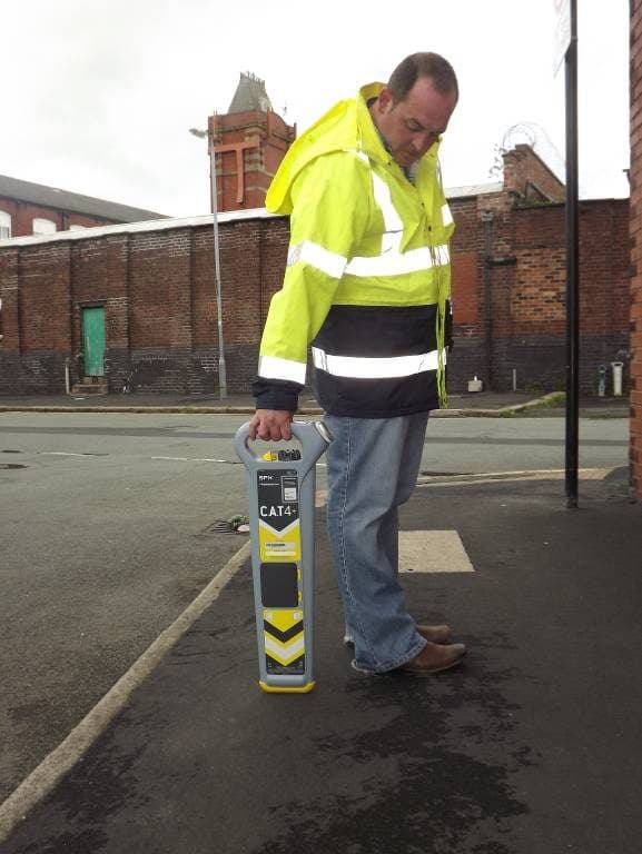 Operative following the traced line along the footway with the CAT4 held low.